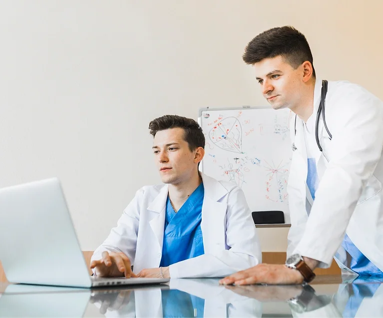 Healthcare professionals reviewing safety data on a laptop